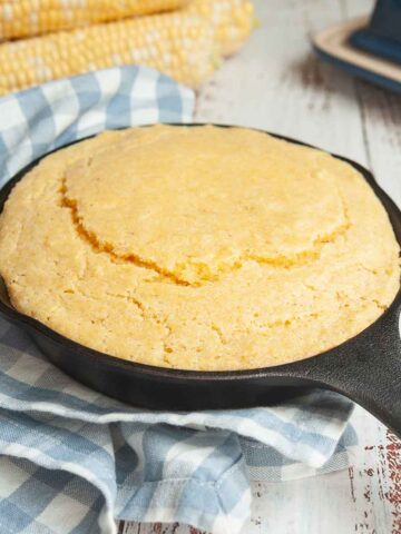 A mini cast iron skillet filled with cornbread.