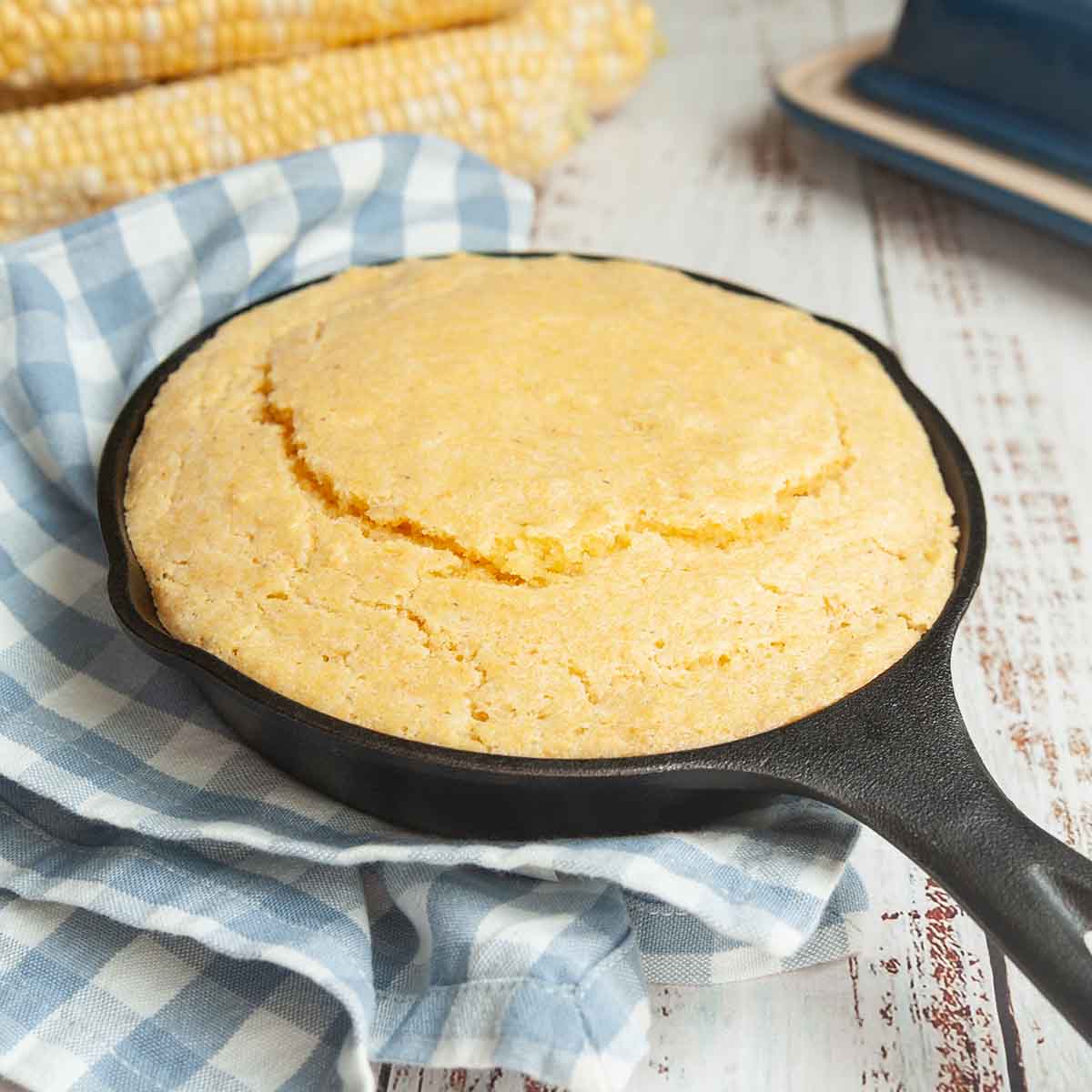 A mini cast iron skillet filled with cornbread.
