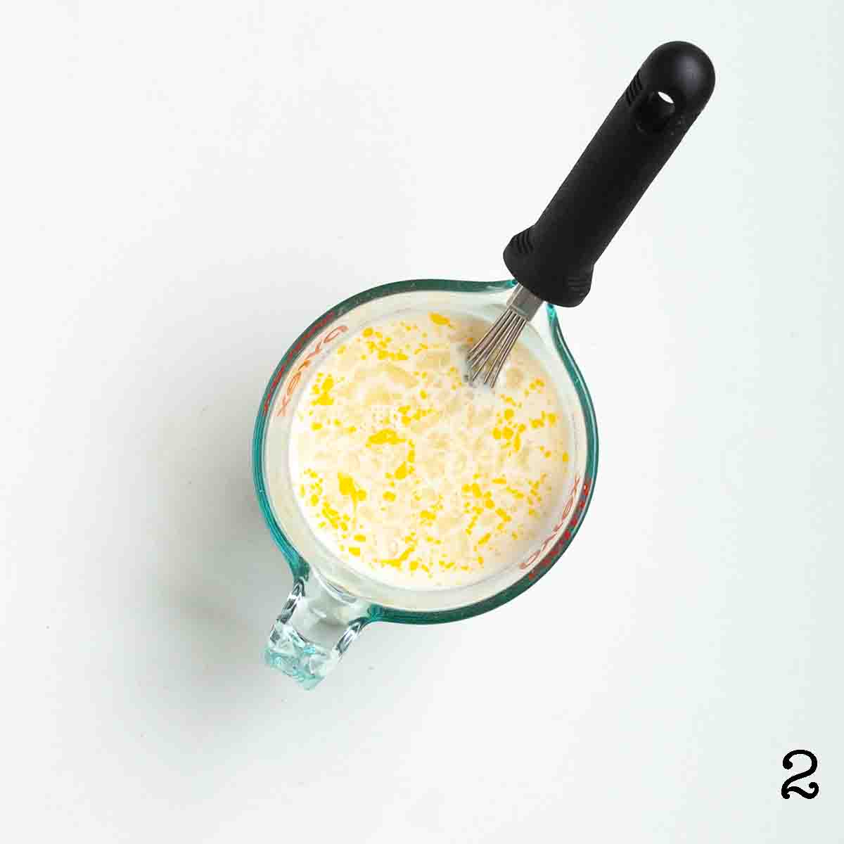 A liquid measuring jug filled with whisked egg and milk.