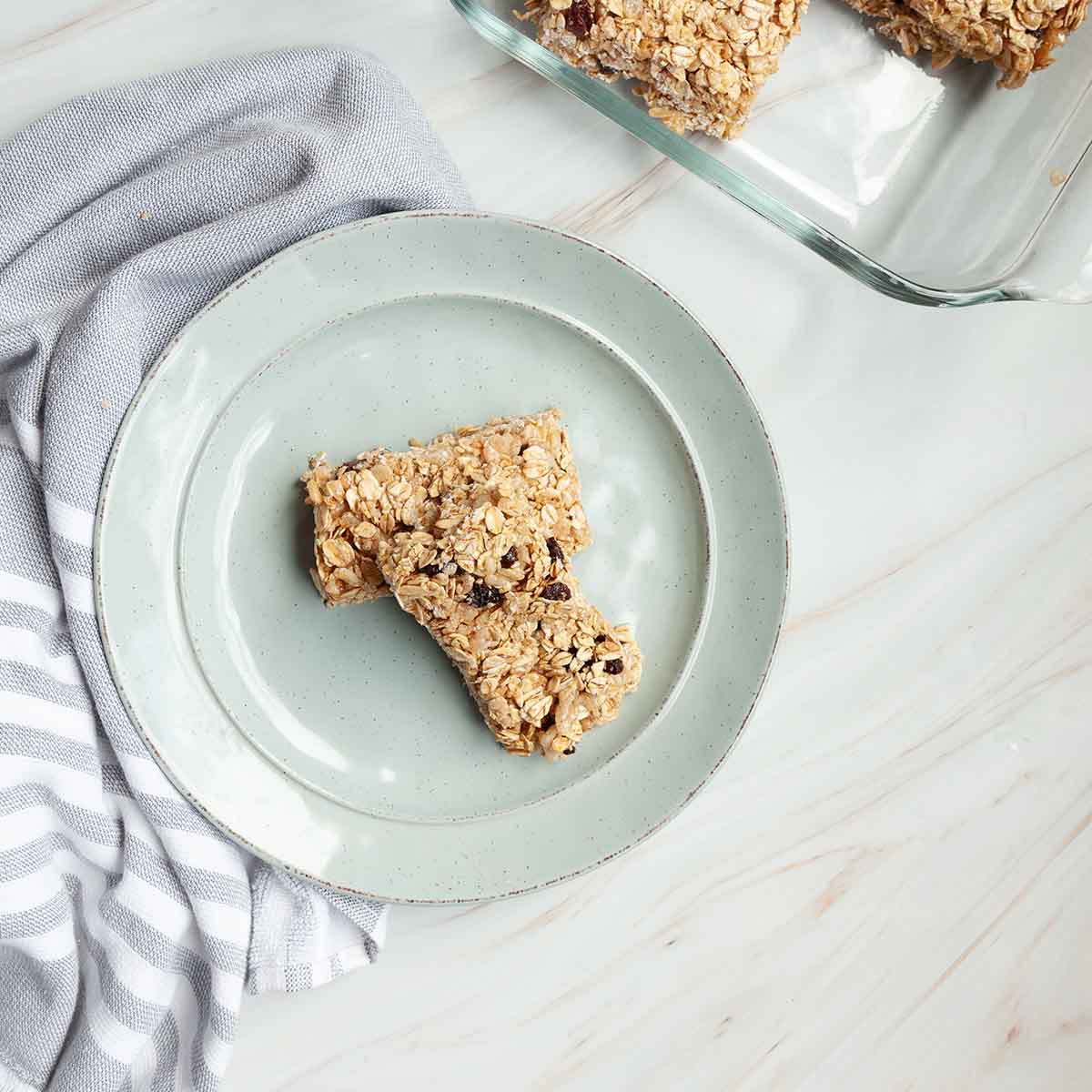 Two oatmeal raisin granola bars on a plate.