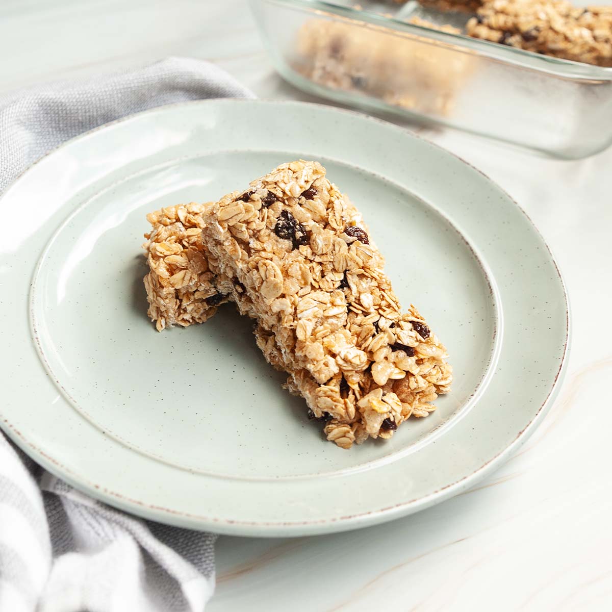 Two oatmeal raisin granola bars on a plate.