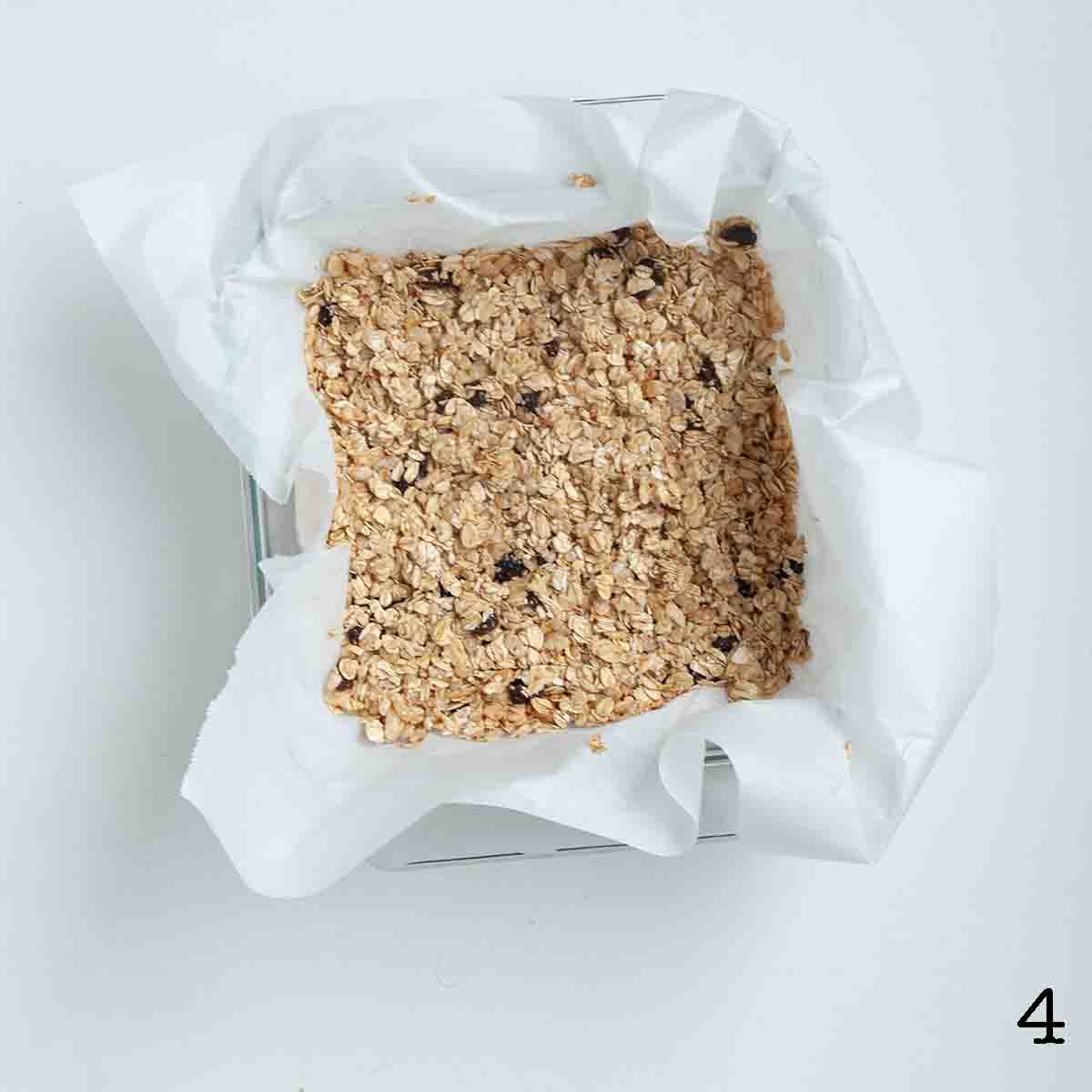 Oatmeal raisin bars pressed into a pan.
