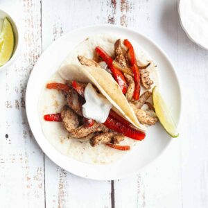 Two tortillas filled with chicken, peppers, and onions.