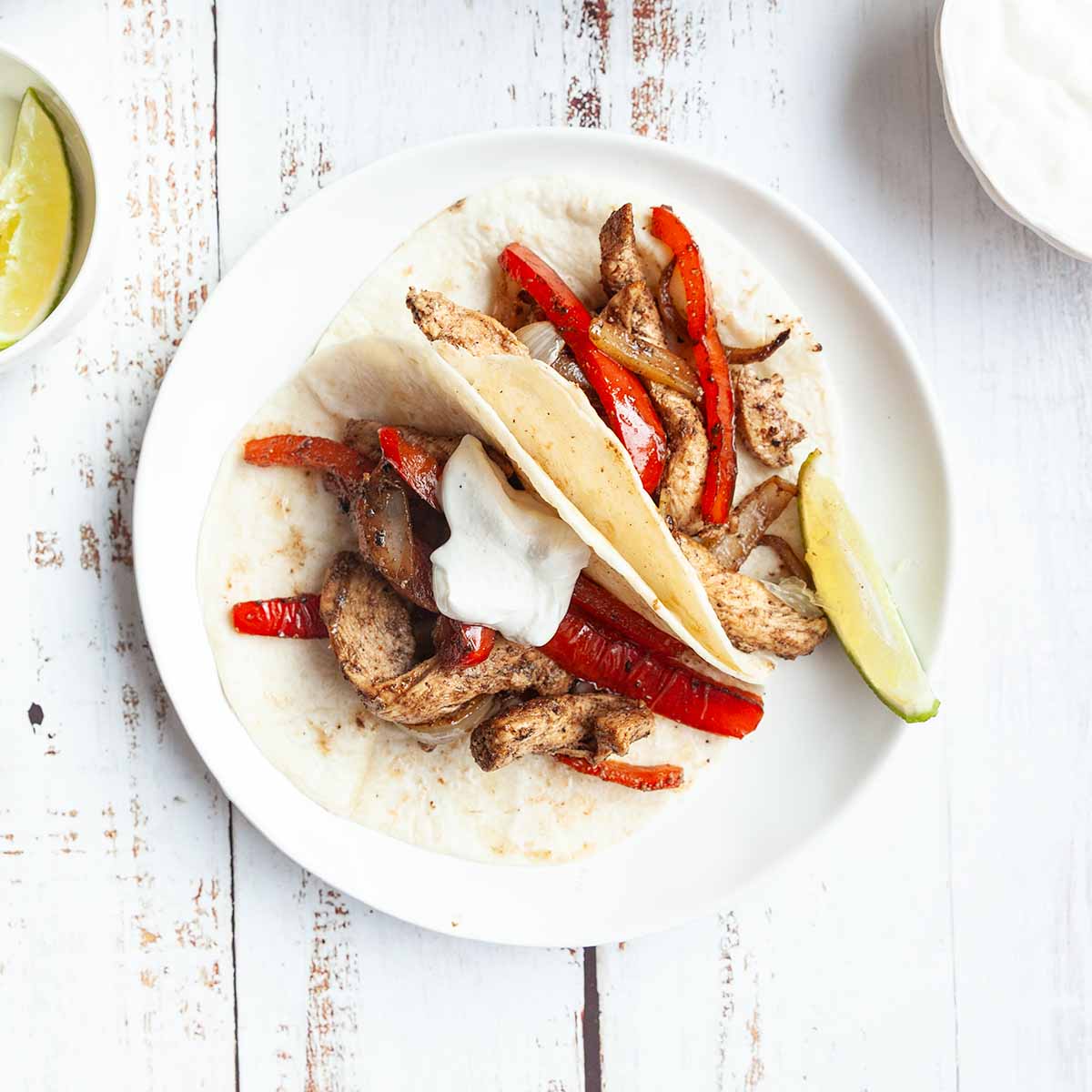 Two tortillas filled with chicken, peppers, and onions.