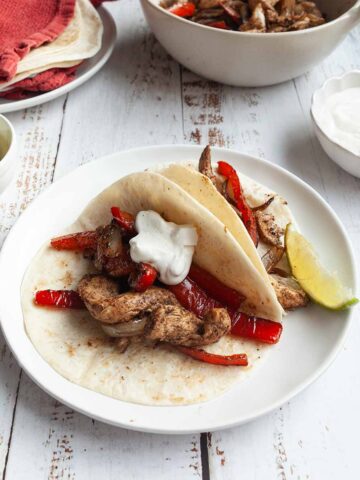 Two tortillas filled with chicken, peppers, and onions.