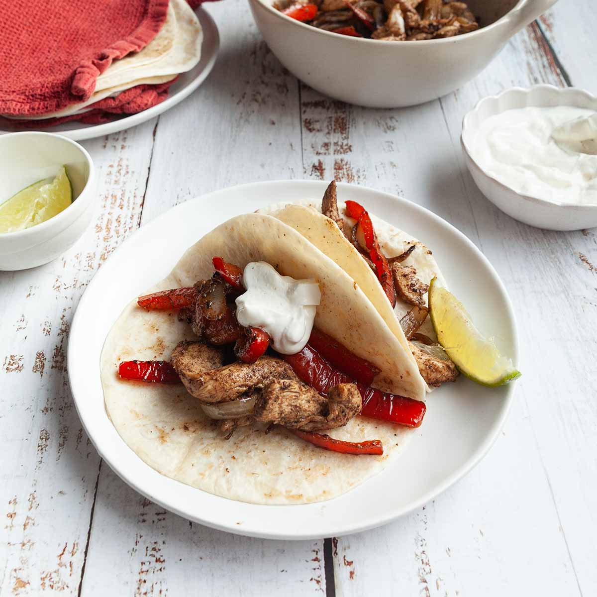 Two tortillas filled with chicken, peppers, and onions.