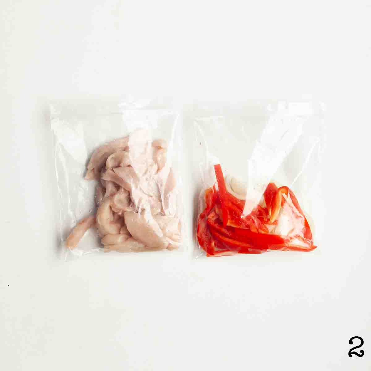 Two bags -- one with strips of raw chicken and one with strips of pepper and onion.