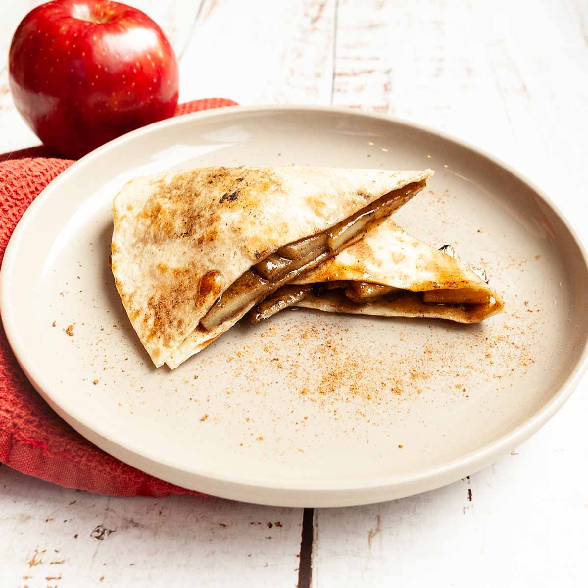Two pieces of apple pie quesadilla on a plate.