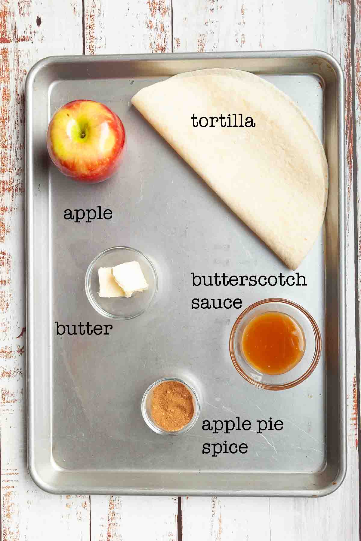 Ingredients for apple pie quesadilla--apple, tortilla, butter, butterscotch sauce, and apple pie spice.