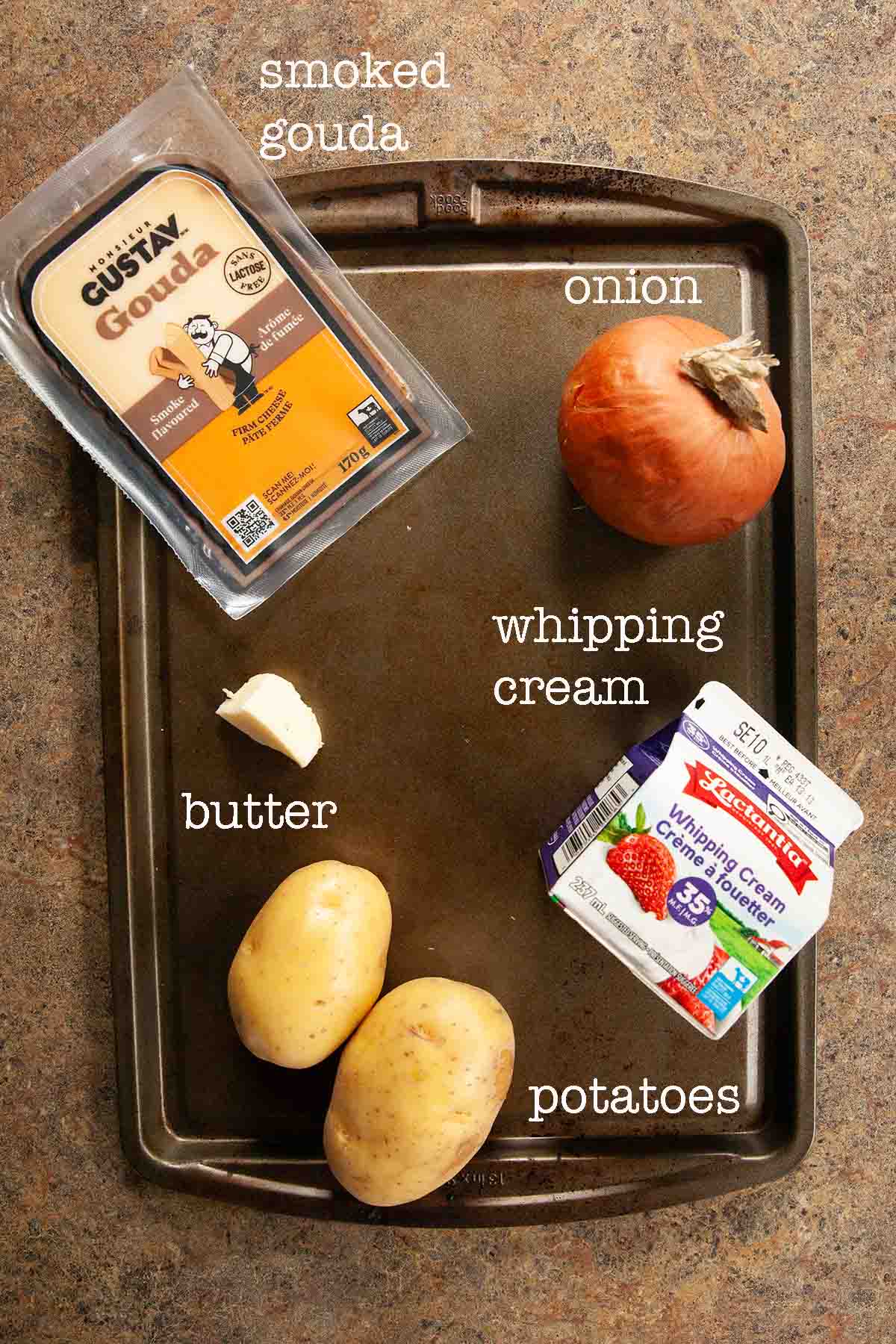 Ingredients for Dutch oven potato gratin--smoked gouda, onion, whipping cream, potatoes, and butter.