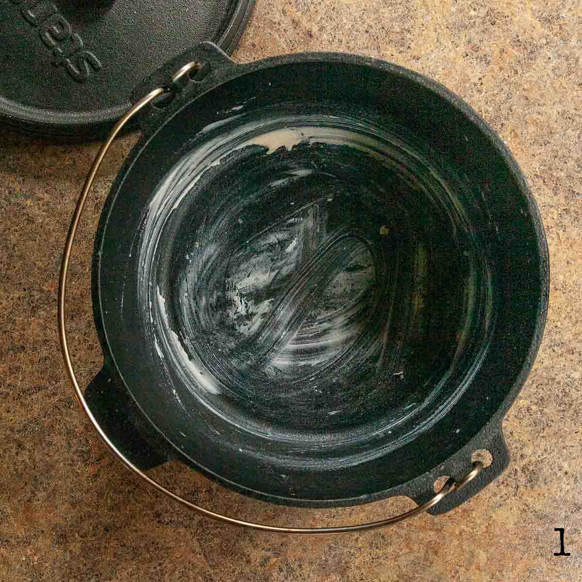 A Dutch oven coated with butter.